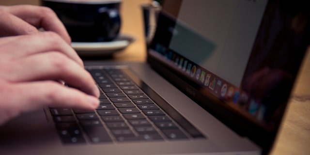 Detail of someone typing on the keyboard of an Apple MacBook Pro laptop computer in a cafe, taken on Nov. 18, 2016. 